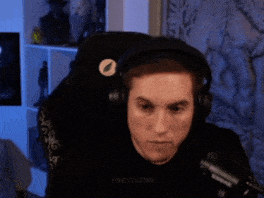 a man wearing headphones and a shure microphone has the name tibetaenn on his shirt