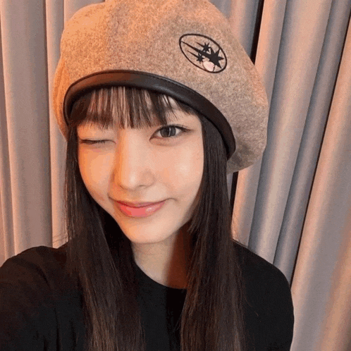 a woman wearing a hat with a star on it winks