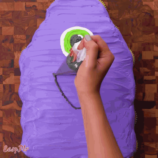 a person is frosting a purple cake that says easy pie on it