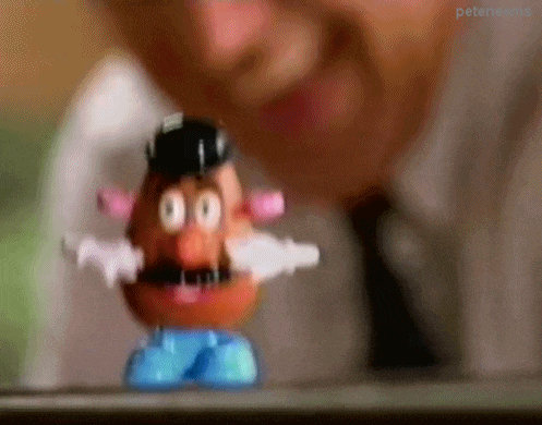 a man is looking at a mr potato head toy .