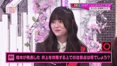 a girl is sitting in front of a pink sign that says q1