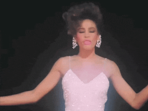 a woman in a white dress and earrings is dancing