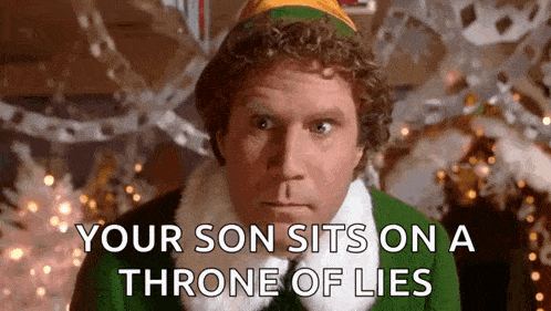 a man dressed as an elf is sitting on a throne of lies in front of a christmas tree .