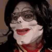 a close up of a person 's face with glasses and a red shirt .