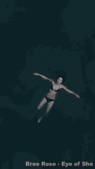 a woman in a bikini is swimming in the ocean and the words bree rose eye of she are below her