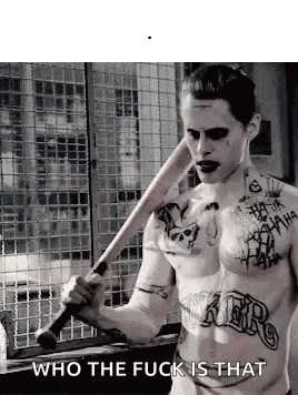 a shirtless man with tattoos on his chest is holding a bat and says `` who the fuck is that '' .