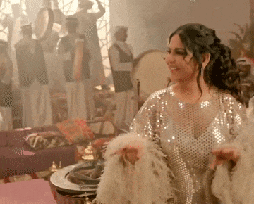 a woman in a white sequined dress is dancing