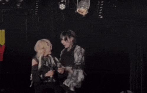 a man and a woman are dancing on a stage in a dark room .