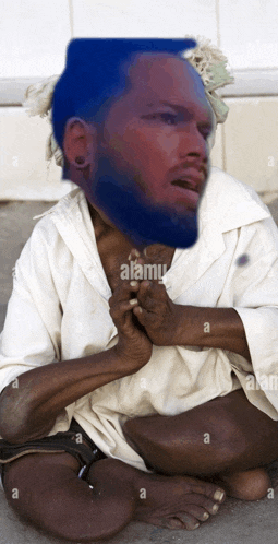 a man with a blue beard is sitting on the ground with alamy written in the corner