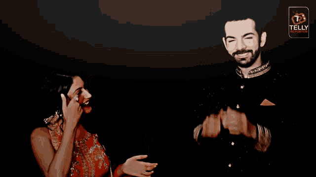 a man is covering his face with his hands while a woman laughs next to him