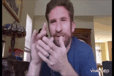 a man with a beard and a ring on his finger is talking to someone on a video call