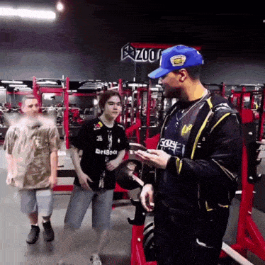 a man in a blue hat is talking to a boy in a black shirt that says betboo on it