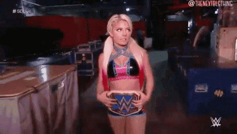 a woman in a bikini is holding a wrestling belt and standing in a room .
