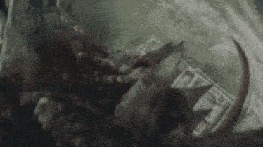 a man in a wheelchair is being attacked by a monster with horns .