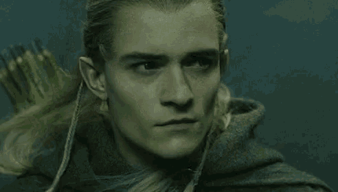 a close up of a man 's face with elf ears and a bow and arrow .