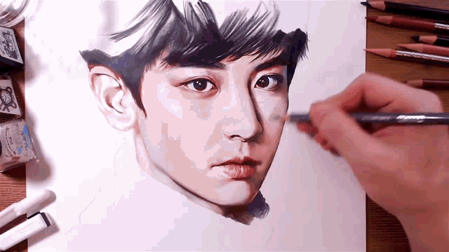 a person is drawing a man 's face with pencils