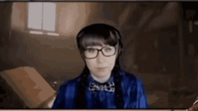 a woman wearing glasses and headphones holds a piece of paper .
