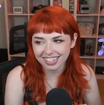 a woman with red hair is smiling at the camera