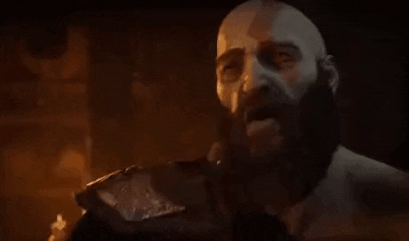 a bald man with a beard is holding his fist to his mouth .