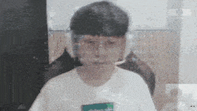 a boy wearing headphones and a white shirt is looking at the camera .