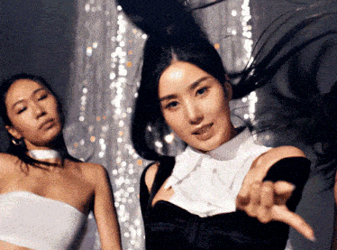 a woman in a black and white dress is pointing
