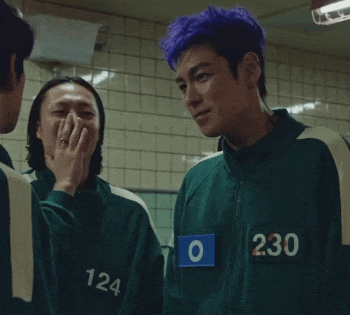 a man with purple hair is wearing a green jacket with the number 230 on it