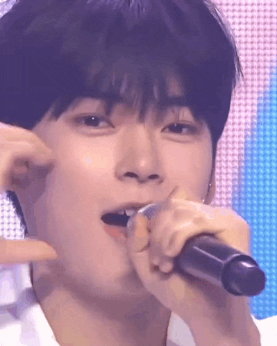 a close up of a person singing into a microphone