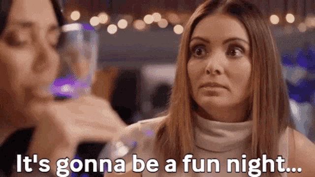 a woman says it 's gonna be a fun night while drinking a glass of wine
