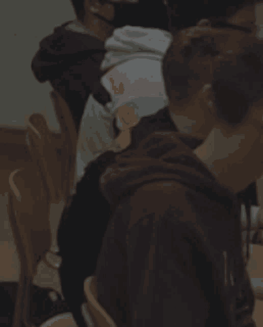 a group of people are sitting in chairs and one of them is wearing a hoodie that says ' a ' on it