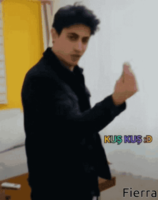 a man in a black jacket is giving the middle finger in front of a sign that says ' tierra '