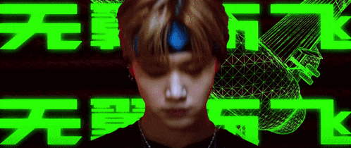 a young man wearing a headband is standing in front of a green background with chinese characters .