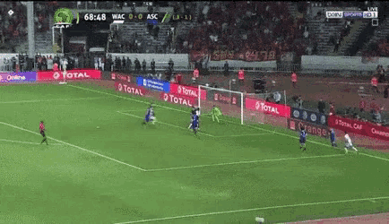 a soccer game is being played in a stadium with ads for total in the background