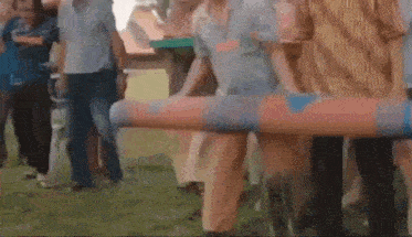 a group of people are carrying a coffin on a stretcher in a park .