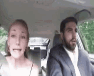 a man and a woman are sitting in a car . the woman is crying while the man is driving .