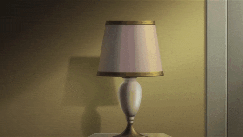 a lamp with a white shade sits on a table in front of a wall
