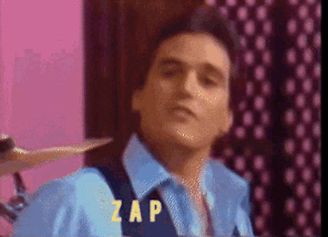 a man in a blue shirt and tie with the word zap written on his chest