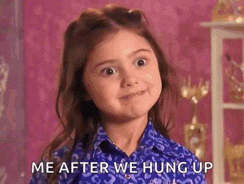 a little girl in a blue shirt is saying me after we hung up