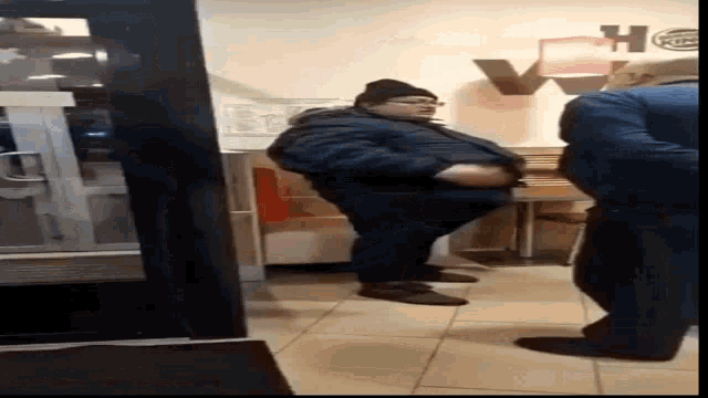 a man in a blue jacket is standing in a burger king restaurant