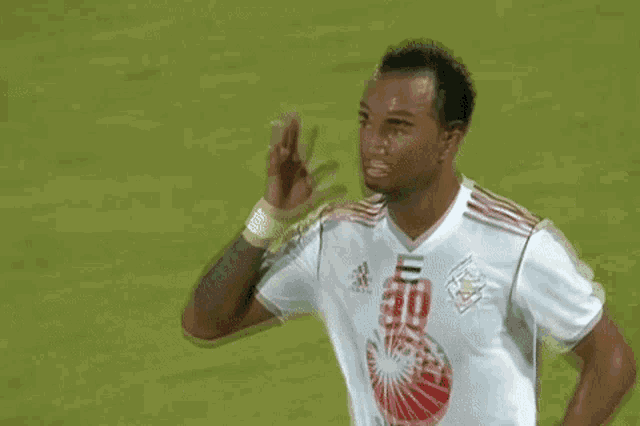 a soccer player wearing a white jersey with the number 30 on it