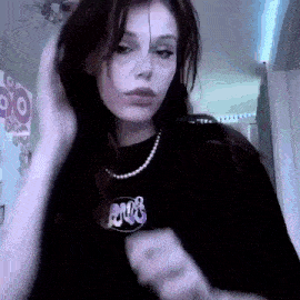 a woman wearing a black shirt and a purple necklace is dancing .