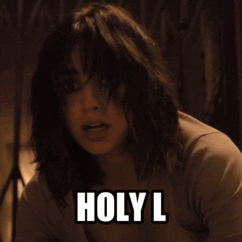 a woman with a surprised look on her face has the word holy l written on her chest