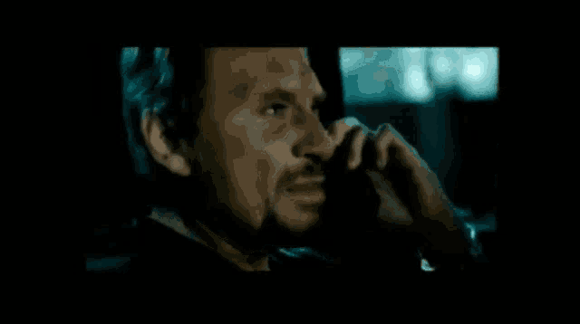 a man with a beard talks on a cell phone
