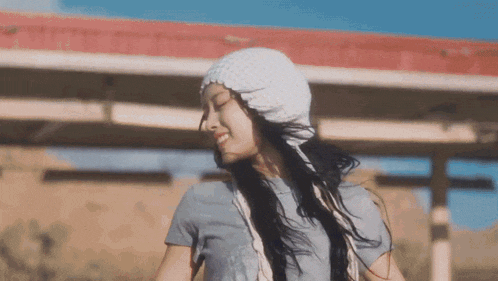 a woman wearing a white hat and a blue shirt is smiling .