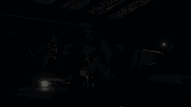 a helicopter is parked in a dark hangar with a red light shining on it
