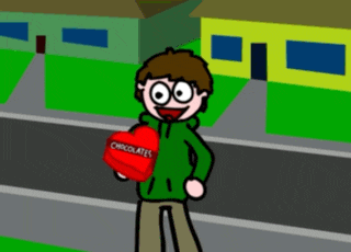 a boy in a green jacket is holding a heart shaped box of chocolates
