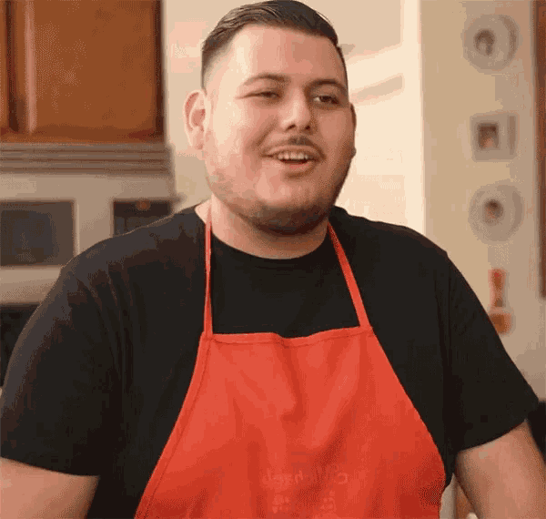 a man wearing a black shirt and a red apron that says arsenal on it