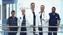a group of doctors and nurses standing next to each other on a balcony .
