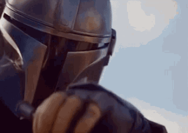 a close up of a person wearing a helmet and gloves holding a gun .