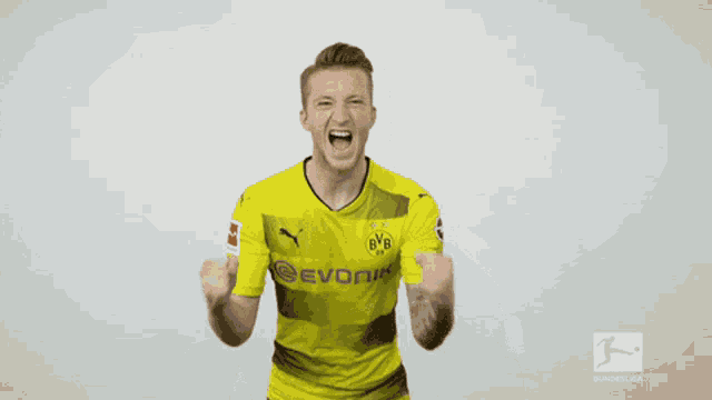 a man wearing a yellow evonik shirt is screaming