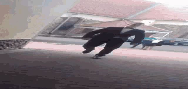 a man in a suit is running on a sidewalk in front of a building